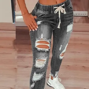 Jean gris taille haute pour femme, délavé et usé, doté d'une taille élastique à cordon.