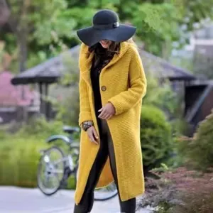 Long yellow hooded knitted cardigan coat for women styled in an outdoor garden setting