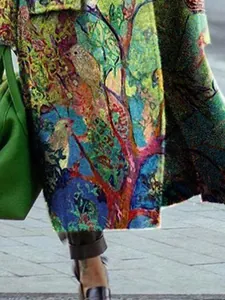 Macro detail of artistic bird and forest print on colorful women's woolen trench coat