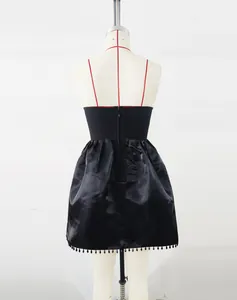 Detailed back view of a black bandage party dress featuring a beaded fringe hemline