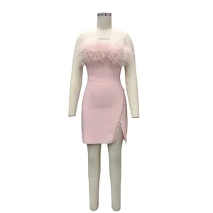 Detailansicht eines rosa Federkleides mit strassbesetztem Schlitz