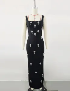 Detail view of black square neck bandage maxi dress with elegant rhinestone flower motifs