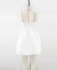 Detailed back view of an elegant white bandage dress with pearl trim for party guests