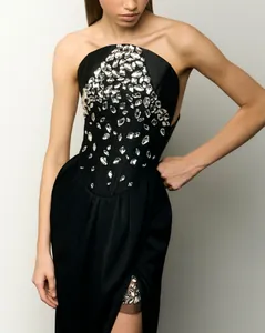 Detailed view of a black strapless evening dress with intricate rhinestone embellishments.