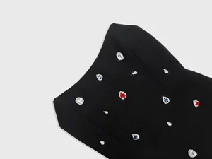 Close-up of colorful sparkling rhinestones on a high-end black bandage party dress