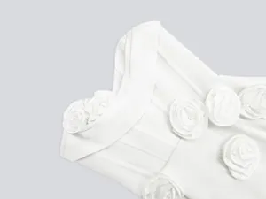 Detailed close-up showing 3D fabric rose decorations on a white bandage party dress