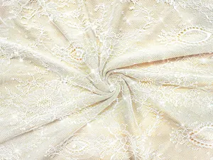 Macro view of exquisite white lace fabric with sparkling crystal embellishments for gown