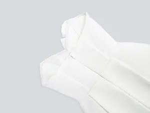 Detailed view of white strapless bandage dress showing ribbed texture and zipper detail.