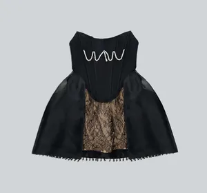 Detailed view of a black corset dress featuring wavy pearl accents and lace inserts