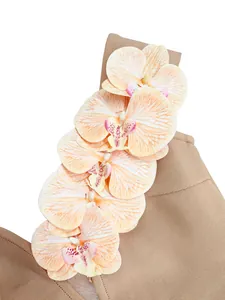 Close-up detail of artificial orchid flowers on elegant tan bandage dress