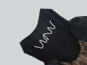 Detailed view of pearl V-shape embellishment on black lace bandage evening dress