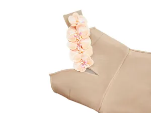Macro detail of a beige bandage dress featuring elegant floral one-shoulder design