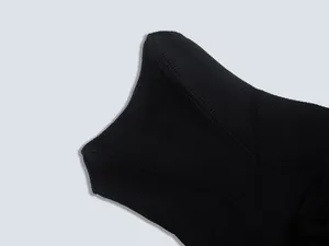 Close-up detail of black ribbed bandage fabric showing texture and stitching lines.