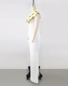 Side profile detail of elegant white one-shoulder bandage dress with floral embellishments.