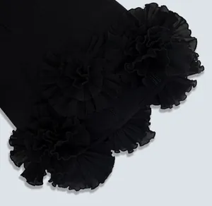 Close-up of pleated floral detail on a high-end black bandage mini dress for party wear