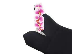 Detail of black one-shoulder bandage dress with elegant pink orchid flower decoration