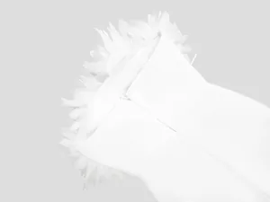Primer plano de un vestido de noche blanco tipo bandage con delicados pétalos 3D
