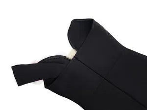 Detailed macro view of black one-shoulder bandage dress with elegant flower accent.