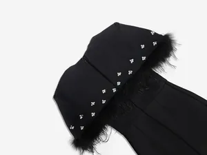 Detalle del vestido bandage negro con plumas de avestruz y decoración de cristales