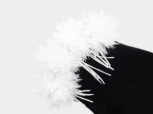 Detalle de cerca de flores 3D blancas decorativas en un vestido de noche negro