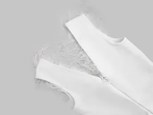 Λεπτομερής προβολή λευκού bandage φορέματος με φτερά στρουθοκαμήλου και υφή πλεκτού υφάσματος