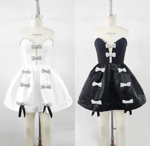 Elegante zwart-witte feestjurken met sprankelende strass-strikken op mannequins