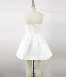Gedetailleerd achteraanzicht van een witte strapless feestjurk met rits op pop