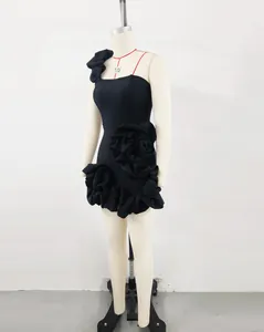 Detail of black mini cocktail dress with ruffled flower accents and puff hemline