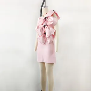 Detail of Barbie pink satin dress featuring three large decorative bows on the front