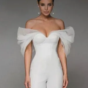 Detailed view of white off-the-shoulder jumpsuit with ruffled organza sleeves