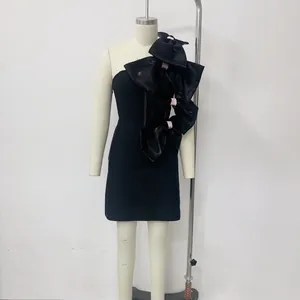 Elegant black mini dress with oversized satin bows displayed on a mannequin for detail view