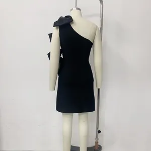 Detailed back view of a black one-shoulder satin dress featuring elegant large bows on mannequin