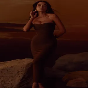 Detailed view of an olive green metallic strapless bandage maxi dress in a scenic setting.