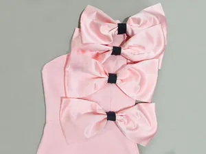 Close-up detail of oversized pink satin bows with black centers on a sweet girly dress