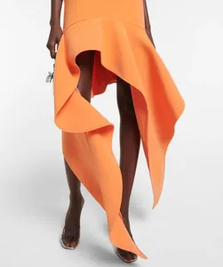 Primo piano dell'orlo asimmetrico a balze di questo elegante abito lungo arancione.