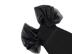 Close-up of black bandage jumpsuit with voluminous organza off-the-shoulder ruffles.