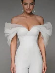 Elegant white off-shoulder jumpsuit featuring dramatic ruffled organza sleeves and bandage fit.