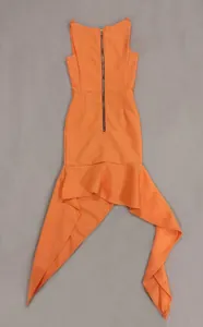 Dettaglio di un elegante abito in maglia arancione con orlo irregolare e zip posteriore