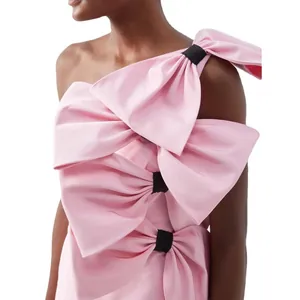 Elegant Barbie pink satin dress with large decorative bows and one-shoulder design