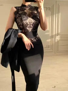 Detail of black lace bodice on a sophisticated bodycon bandage dress with side lighting.
