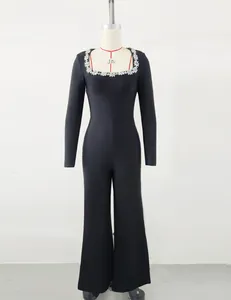 Close-up detail of black square neck jumpsuit featuring elegant rhinestone flower neckline.