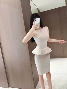 Detailed view of elegant beige knit two-piece set with peplum top and bodycon skirt