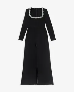 Elegant black long sleeve jumpsuit featuring a crystal-embellished square neckline and flared legs.
