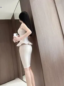 Side view of elegant beige peplum knit top and bandage pencil skirt two-piece set