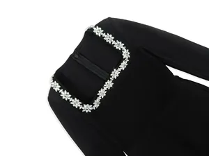 Close-up detail of sparkling rhinestone floral neckline on a black square neck jumpsuit.