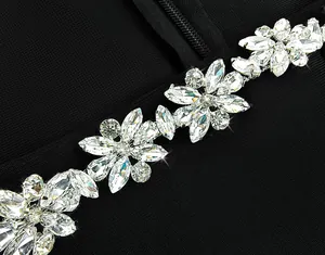 Close-up of luxury floral rhinestone embellishments on a black long sleeve jumpsuit.