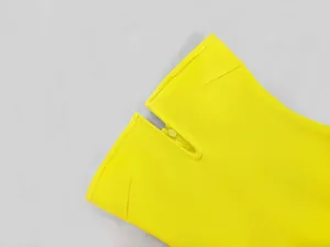 Detailansicht des verdeckten Reißverschlusses und des gelben Bandage-Stoffes des Kleides.