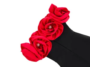 Close-up of a black bandage dress featuring three large red fabric roses with rhinestones