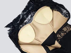 Detail view of interior padded cups and black lace texture on an elegant bandage dress