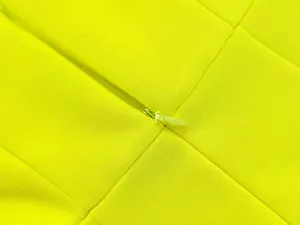 Nahaufnahme des verdeckten Reißverschlusses an einem hochwertigen neongrünen Kleid.